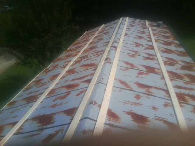 Rusted metal roof panels with new wood purlins before replacement — Storm Damage Roof Repair in Thomas by Roofing Brothers